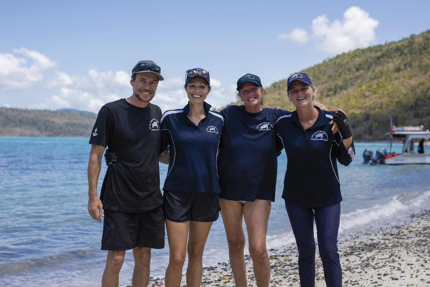 Smiling charity workers on beach