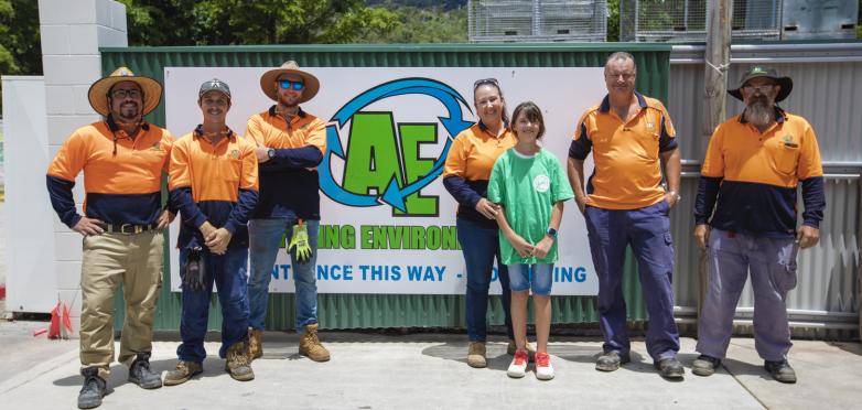 EcoBarge crew in front of sign