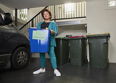 Woman holding container bin in garage